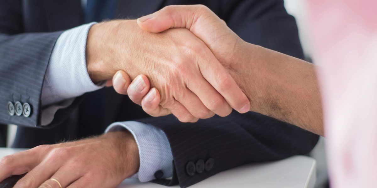 Two professionals shaking hands, symbolizing successful collaboration and agreement on strategies.