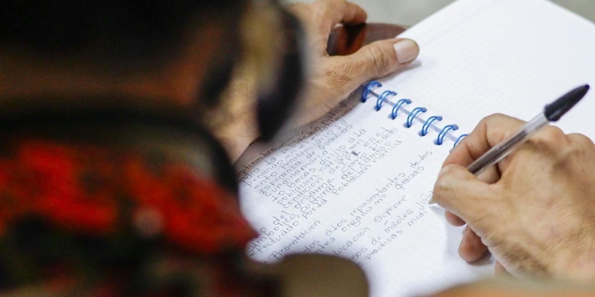 A person looks thoughtfully at notes, contemplating complex information, symbolizing the human effort needed to understand and prevent AI errors.